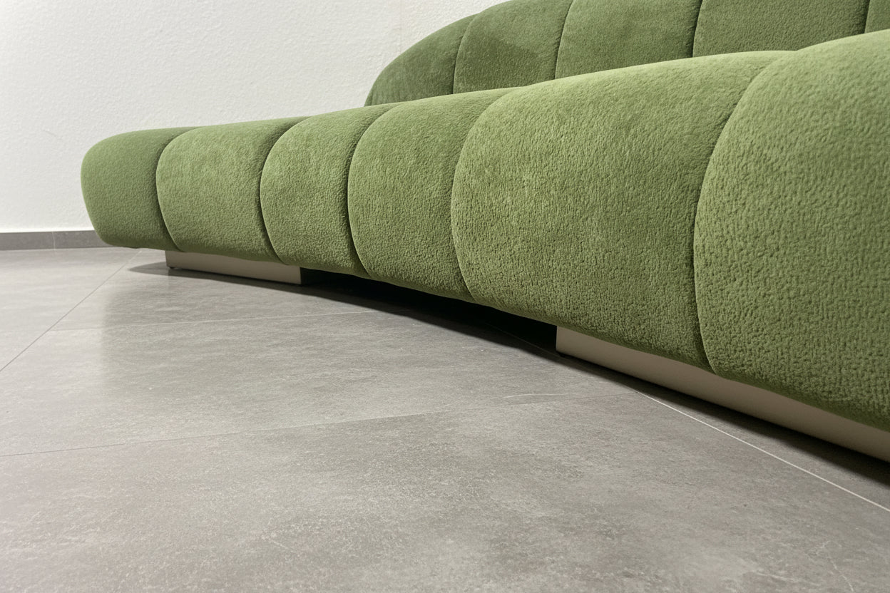 Green upholstered sofa with a brass base