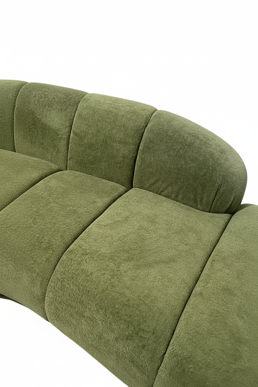 Green sofa with curved design on a white background