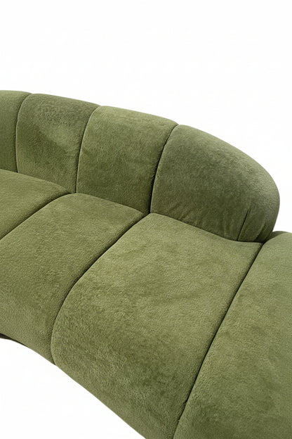 Green sofa with curved design on a white background