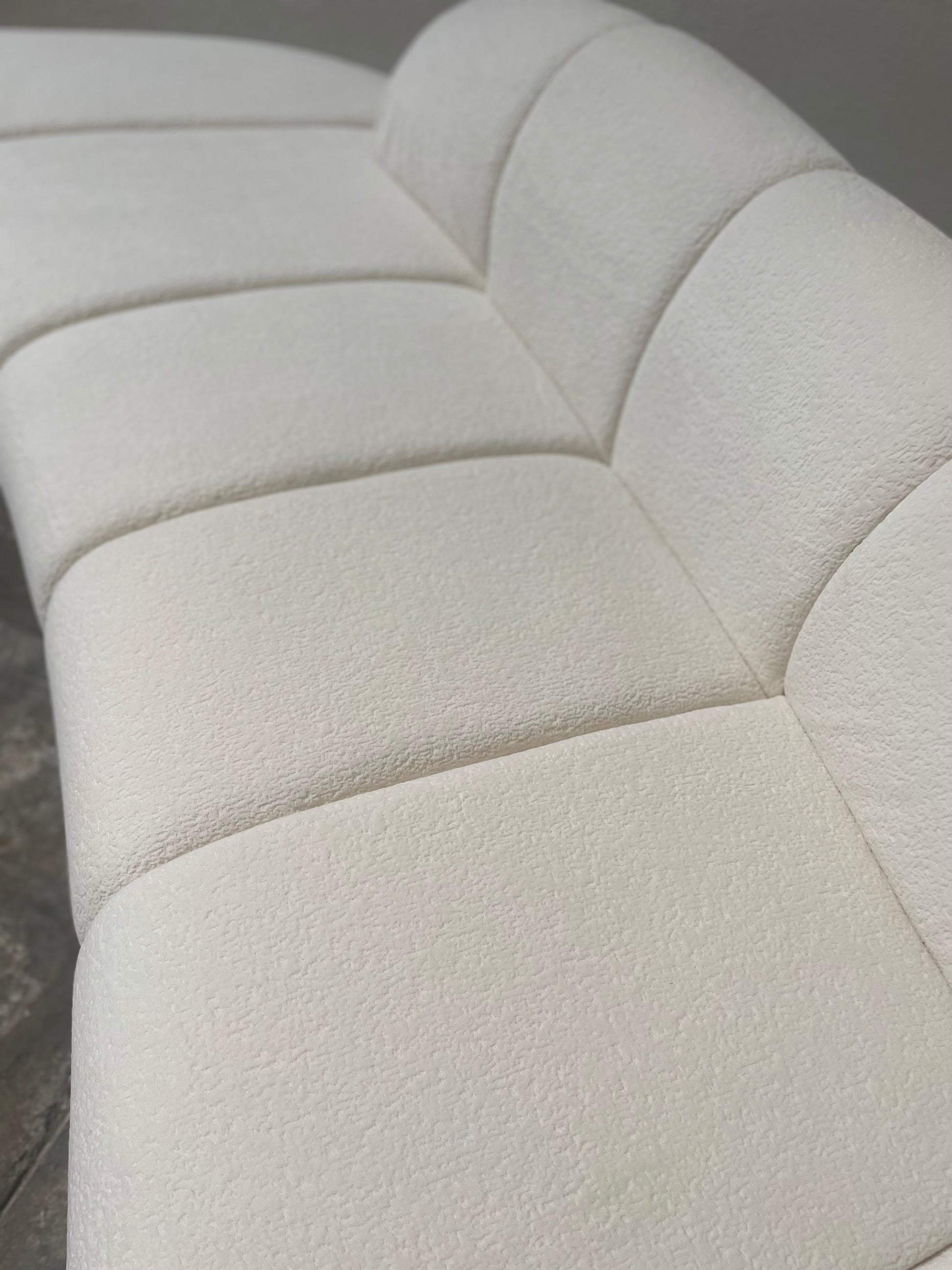 Close-up of a textured fabric of white curved sofa 